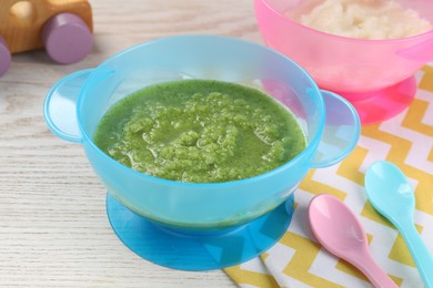 Photo of Healthy baby food. Different tasty puree in bowls on white wooden table