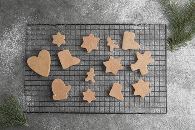 Homemade Christmas cookies. Baking rack with raw gingerbread biscuits on grey table, flat lay