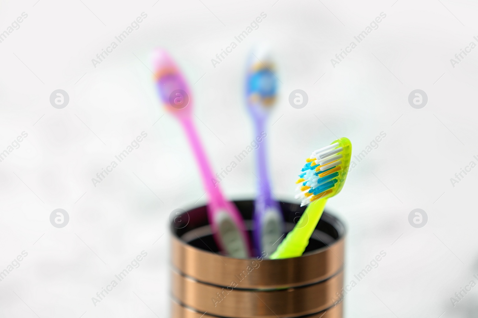 Photo of Cup with toothbrushes on table, closeup. Dental care