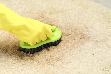 Photo of Woman removing stain from beige carpet, closeup. Space for text