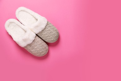Photo of Pair of beautiful soft slippers on pink background, top view. Space for text