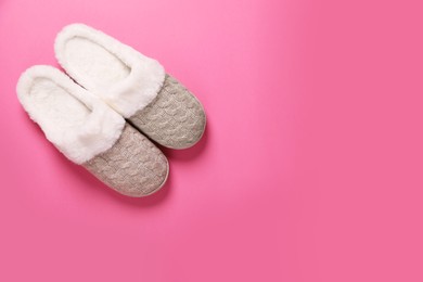 Pair of beautiful soft slippers on pink background, top view. Space for text