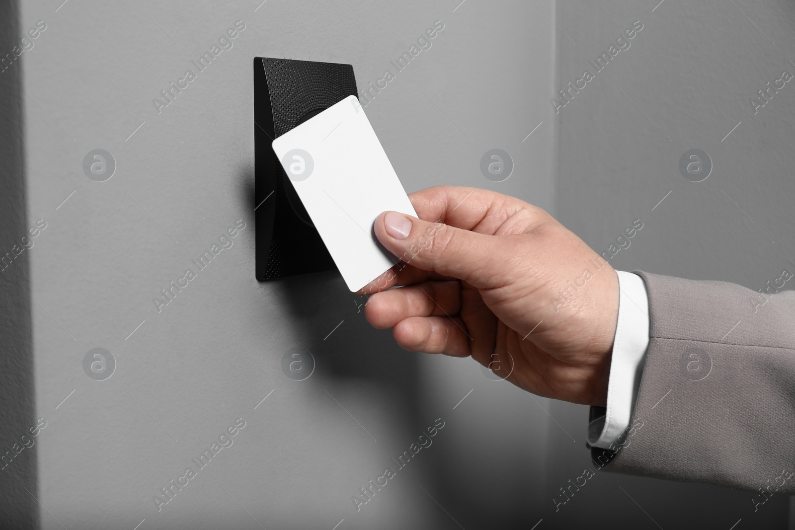 Photo of Man opening magnetic door lock with key card, closeup. Home security