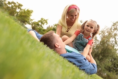 Happy family spending time together in park on green grass