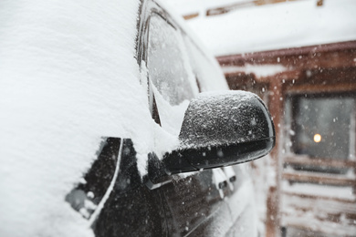 Modern car covered with snow outdoors on winter day, closeup