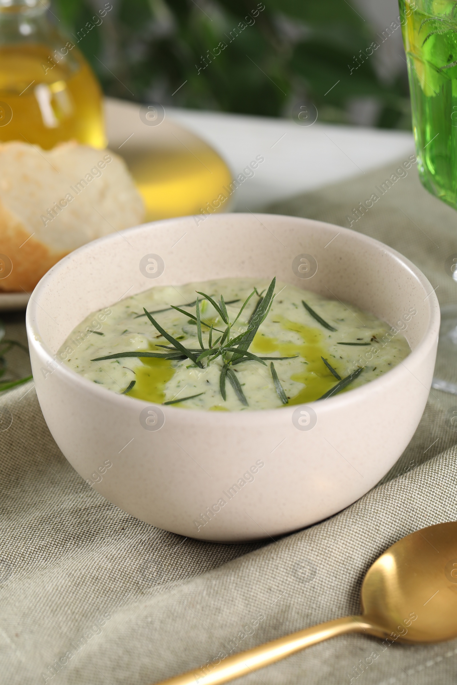 Photo of Delicious cream soup with tarragon, spices and potato in bowl on table