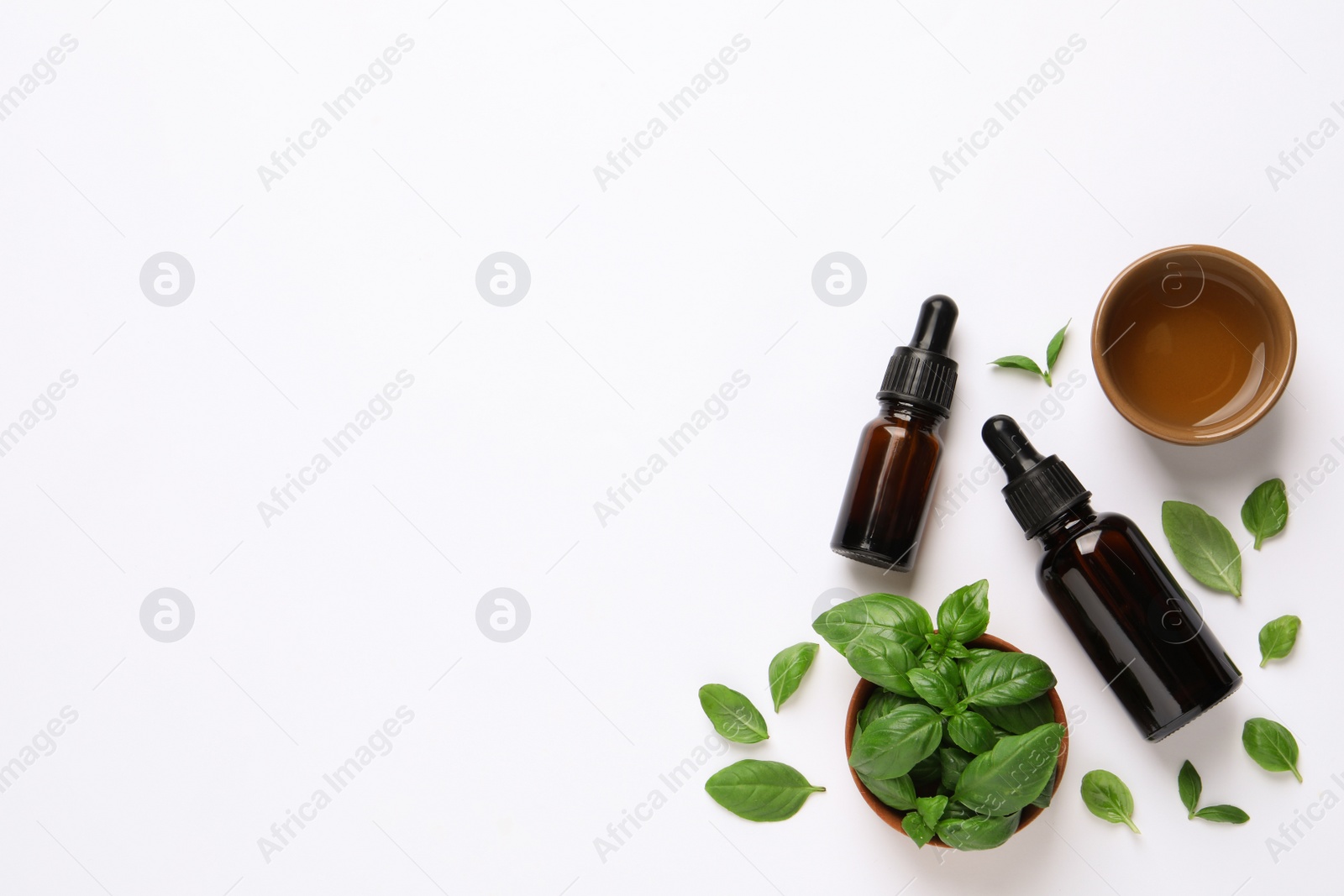 Photo of Essential basil oil with fresh leaves on white background, flat lay. Space for text