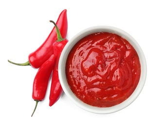 Photo of Bowl with red sauce and fresh chili peppers isolated on white, top view