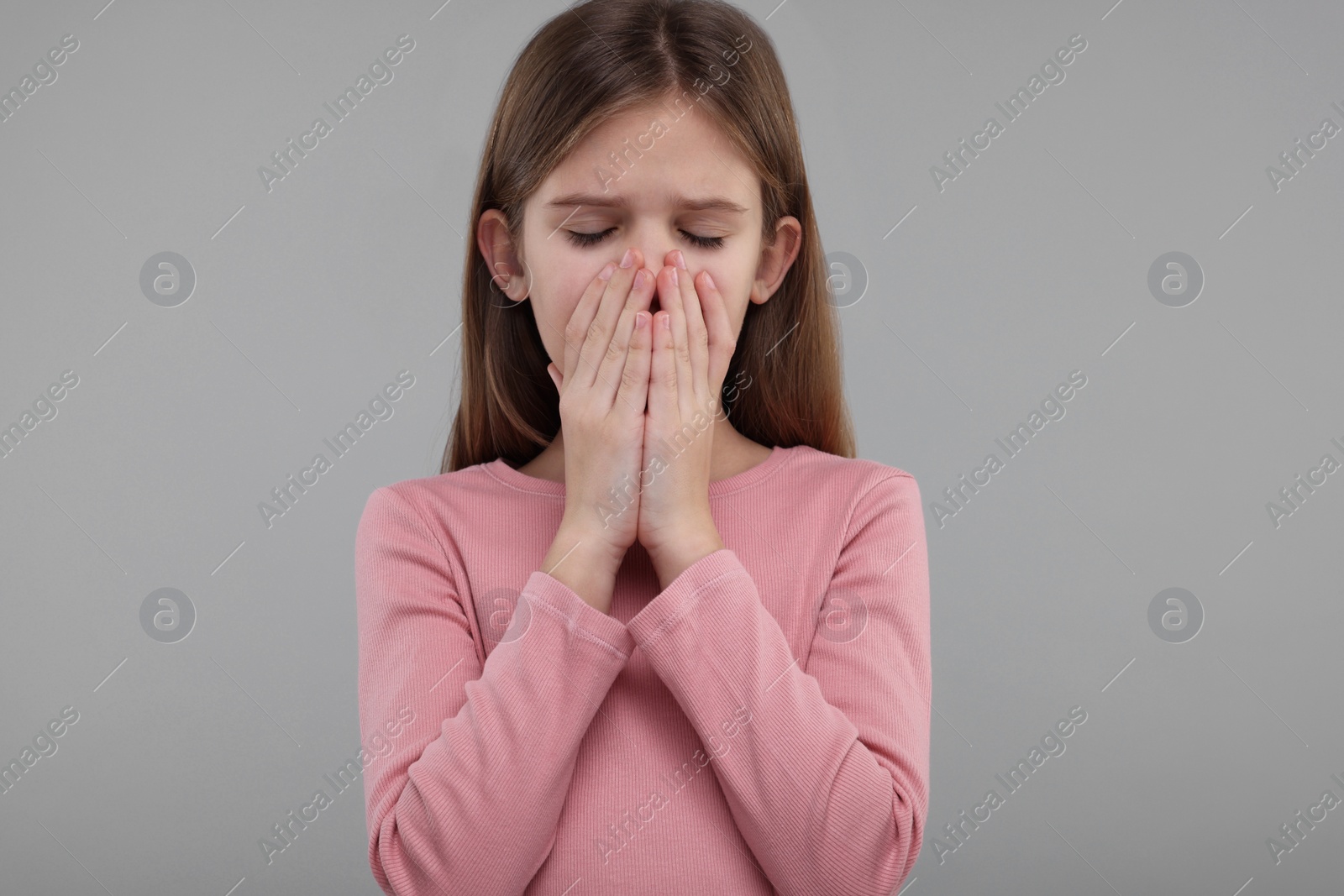 Photo of Sick girl coughing on gray background. Cold symptoms