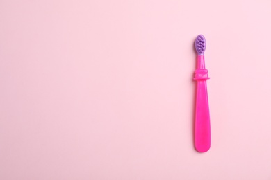 Manual toothbrush for child on color background, top view with space for text