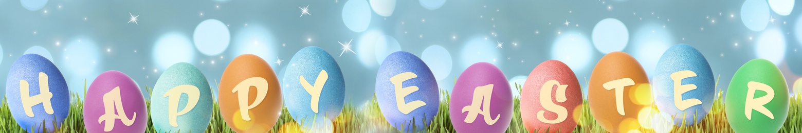 Image of Happy Easter. Colorful dyed eggs on green grass, banner design