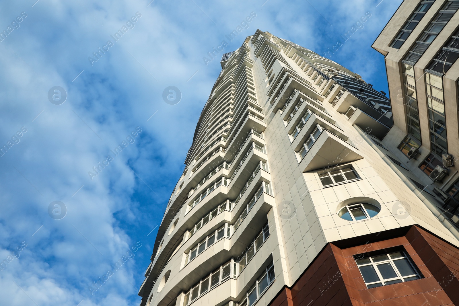 Photo of KYIV, UKRAINE - MAY 23, 2019: Modern dwelling building against sky with clouds