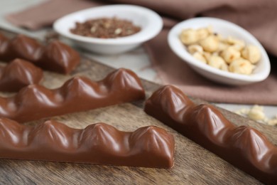 Tasty chocolate bars on wooden board, closeup. Space for text