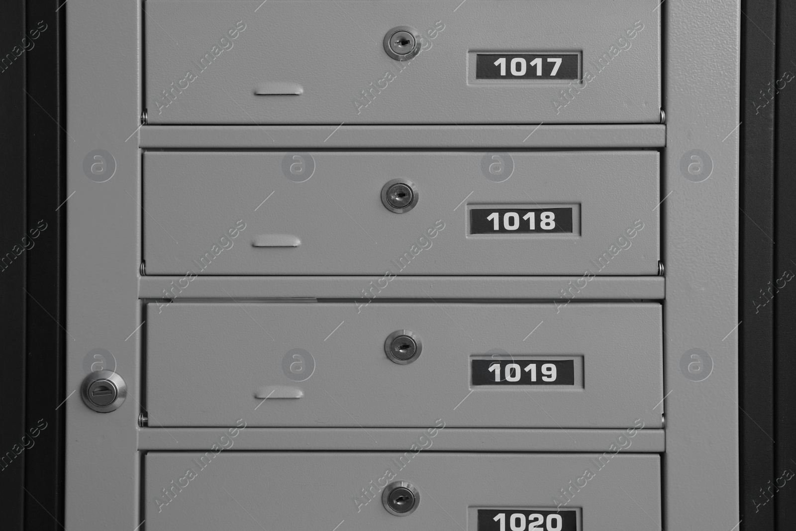 Photo of Closed metal mailboxes with keyholes and sequence numbers indoors