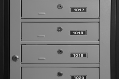 Photo of Closed metal mailboxes with keyholes and sequence numbers indoors