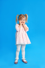 Portrait of cute little girl on blue background