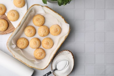 Photo of Tasty sweet sugar cookies in baking dish and mint on white tiled table, flat lay. Space for text