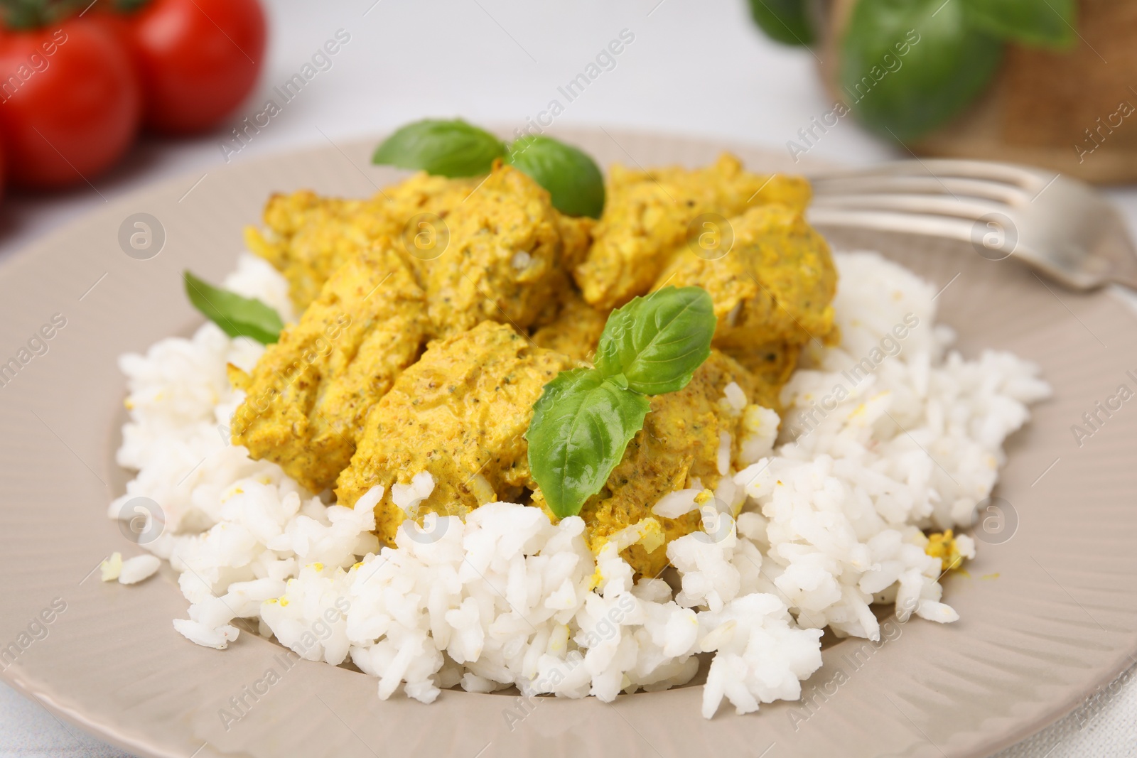 Photo of Delicious rice and chicken with curry sauce on plate, closeup