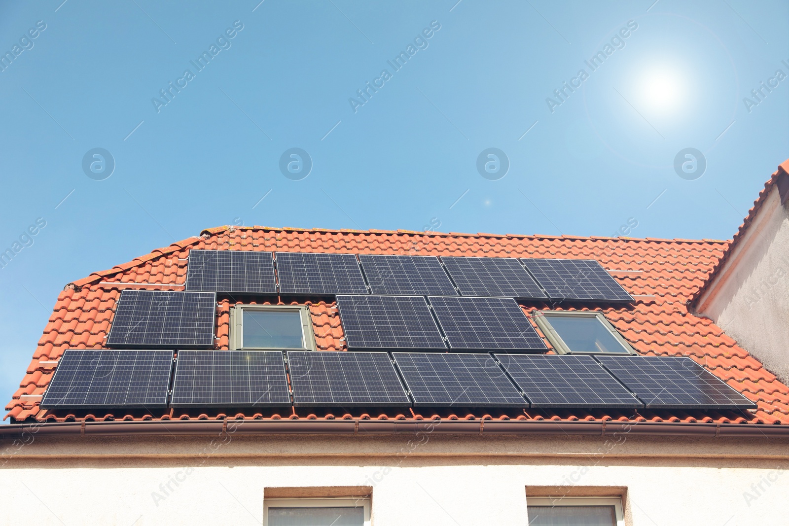 Photo of House with installed solar panels on roof. Alternative energy