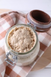 Photo of Sourdough starter in glass jar on table, above view