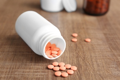 Photo of Bottle with pills on wooden background