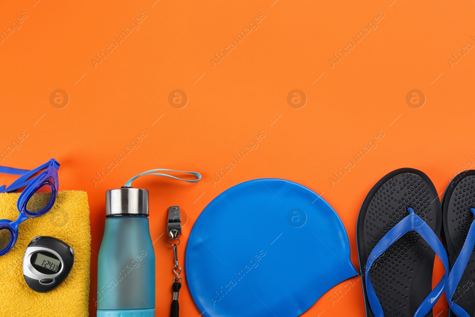 Photo of Flat lay composition with swimming accessories on orange background. Space for text