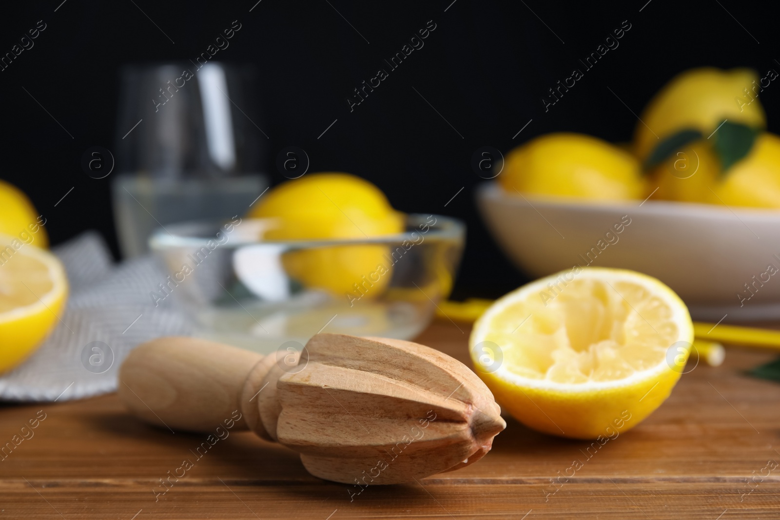 Photo of Citrus reamer and fresh lemons on wooden table