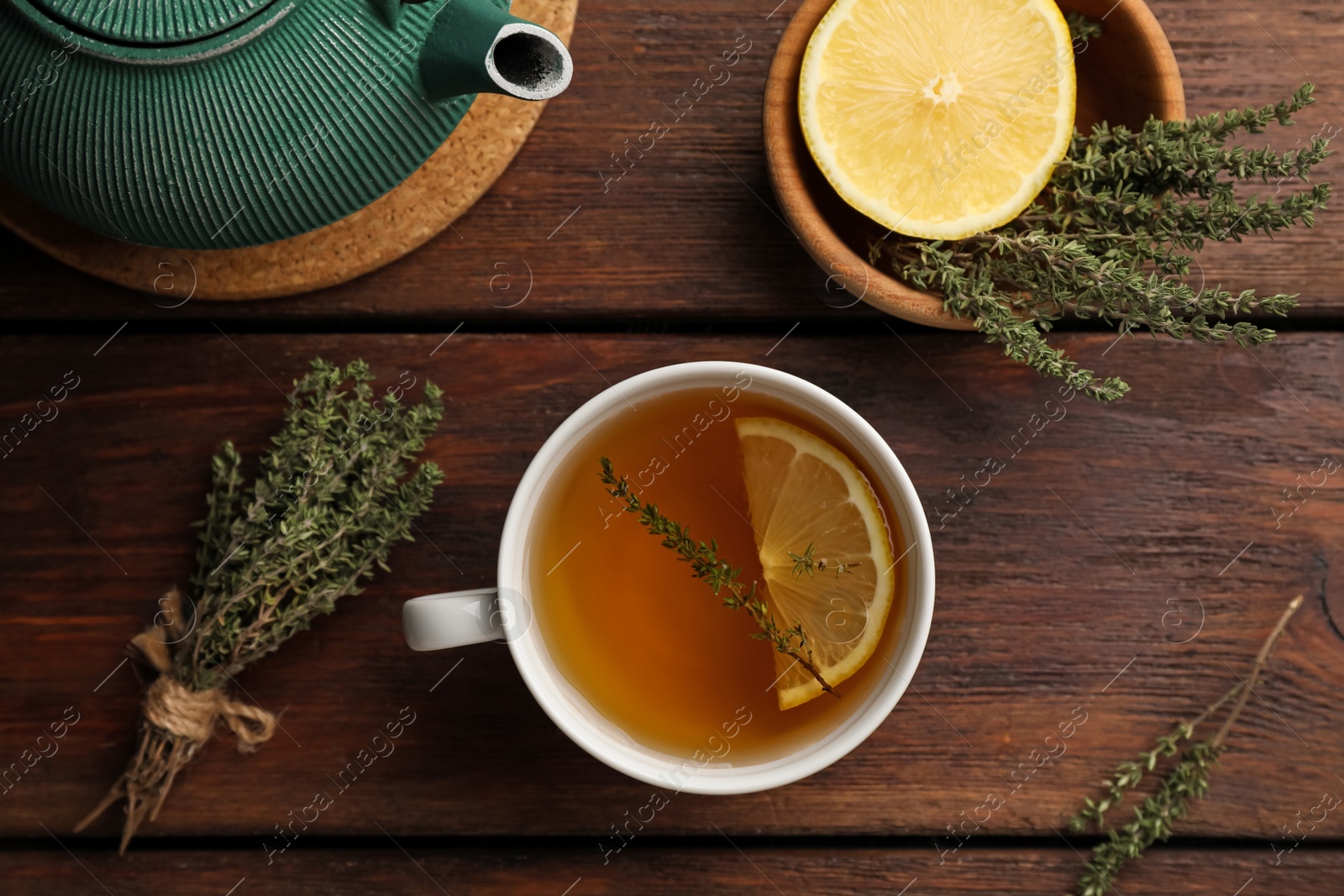 Photo of Aromatic herbal tea with thyme and lemon on wooden table, flat lay