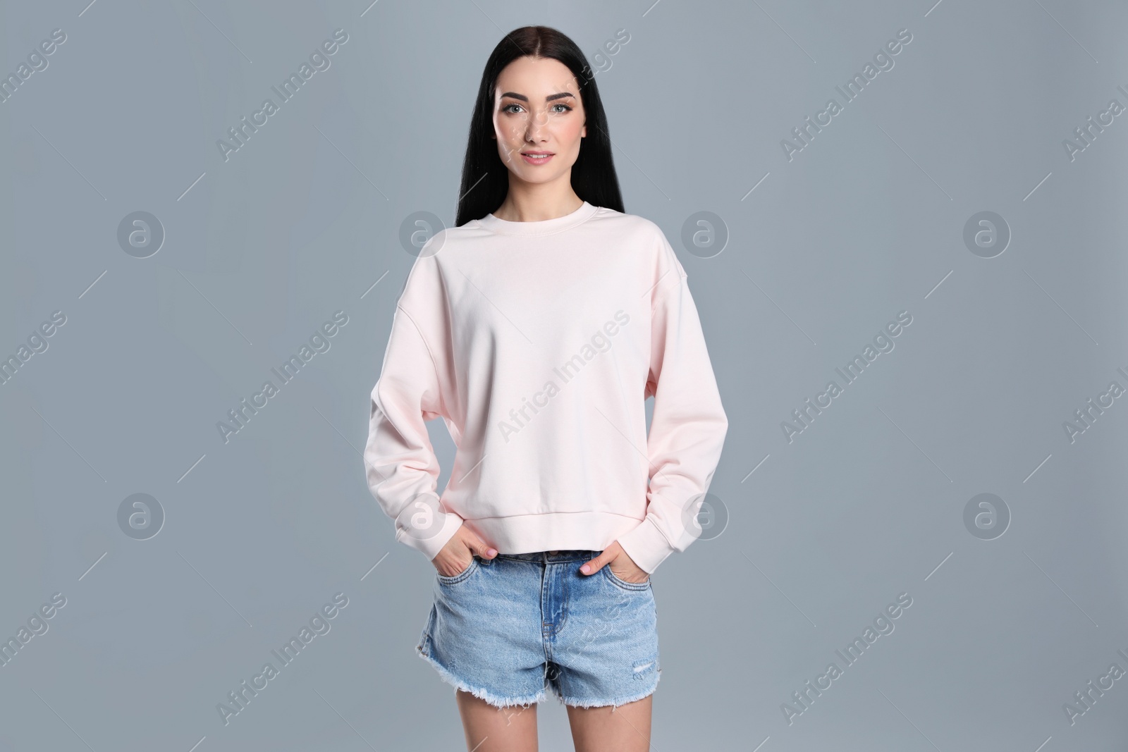 Photo of Portrait of young woman in sweater on grey background. Mock up for design