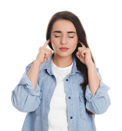 Young woman covering ears with fingers on white background