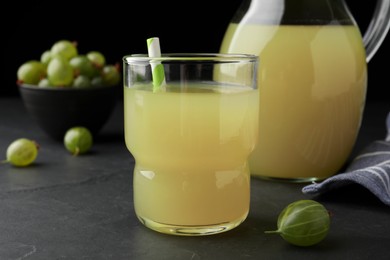 Tasty gooseberry juice in glass on black table