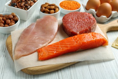 Photo of Fresh meat and other products on white wooden table. Sources of essential amino acids