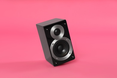 Modern powerful audio speaker on pink background