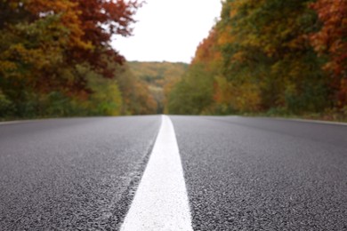 Photo of Beautiful view of asphalt highway going through autumn forest