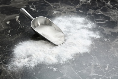 Photo of Scoop and baking soda on grey background. Space for text