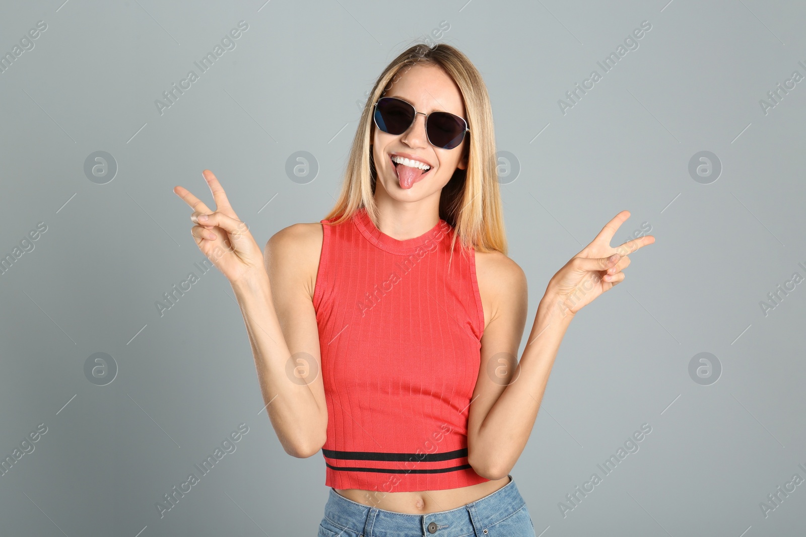 Photo of Beautiful woman in stylish sunglasses on grey background