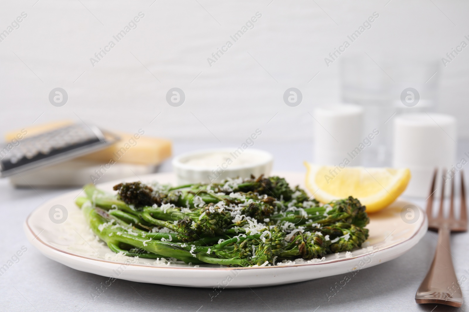 Photo of Tasty cooked broccolini with cheese on table, closeup
