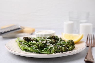 Tasty cooked broccolini with cheese on table, closeup