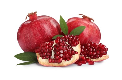 Ripe pomegranates with green leaves on white background
