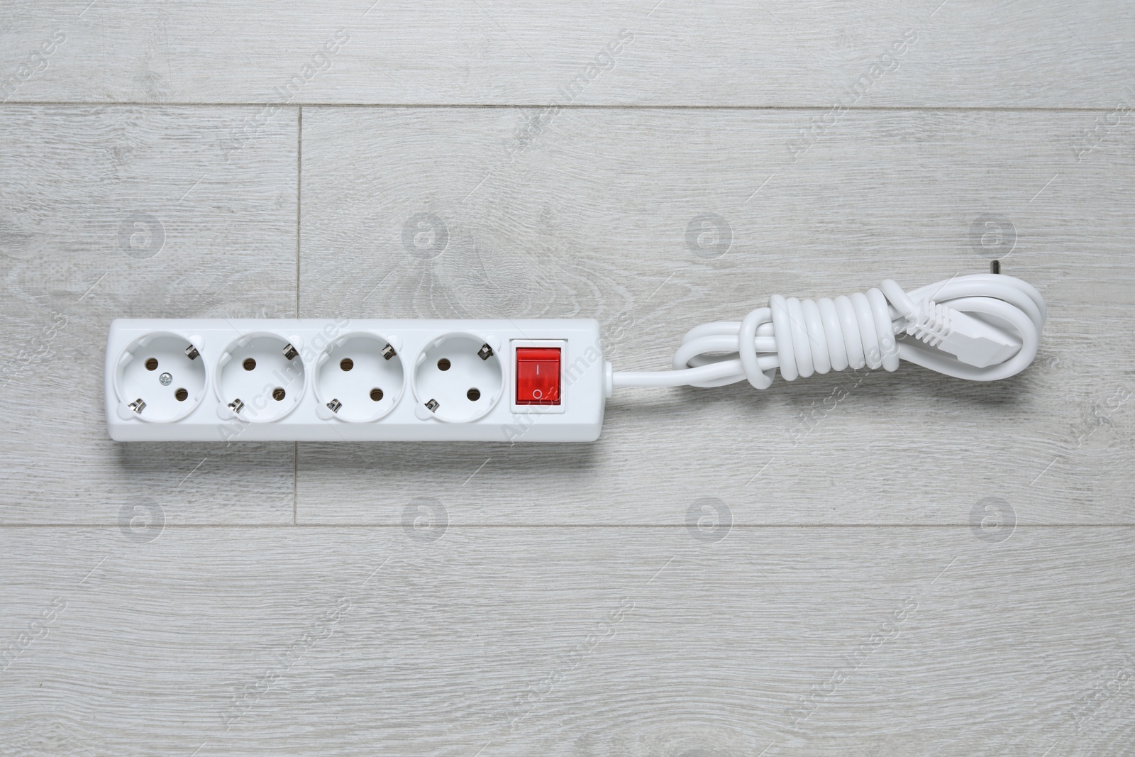 Photo of Power strip on wooden floor, top view. Electrician's equipment