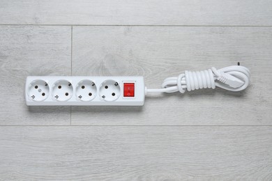 Photo of Power strip on wooden floor, top view. Electrician's equipment