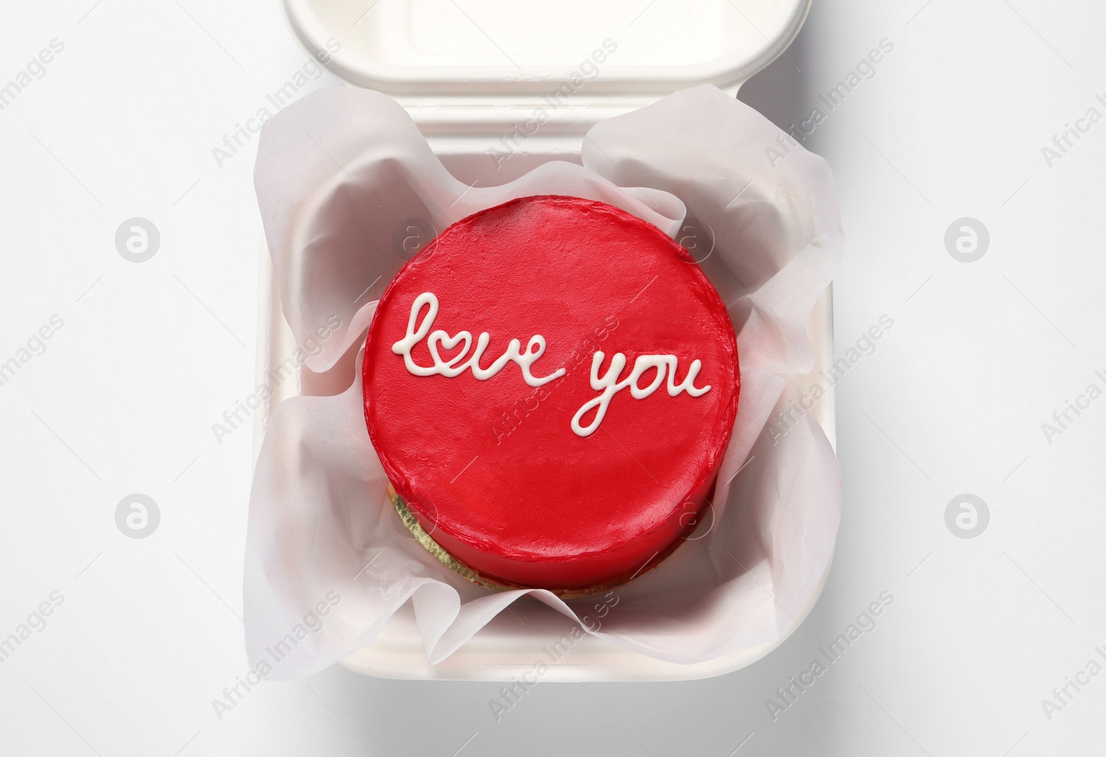 Photo of Bento cake with Love You text in takeaway box on white table, top view. St. Valentine's day surprise