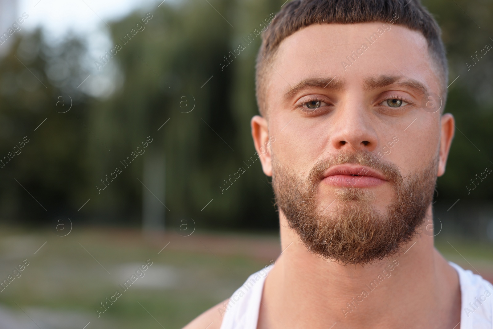 Photo of Portrait of attractive young man outdoors. Space for text