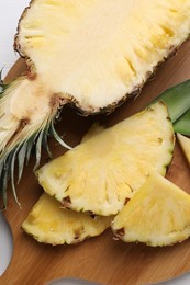 Photo of Ripe juicy pineapple on white table, top view