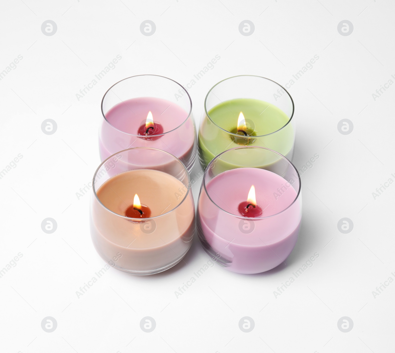 Photo of Color wax candles in glass holders isolated on white