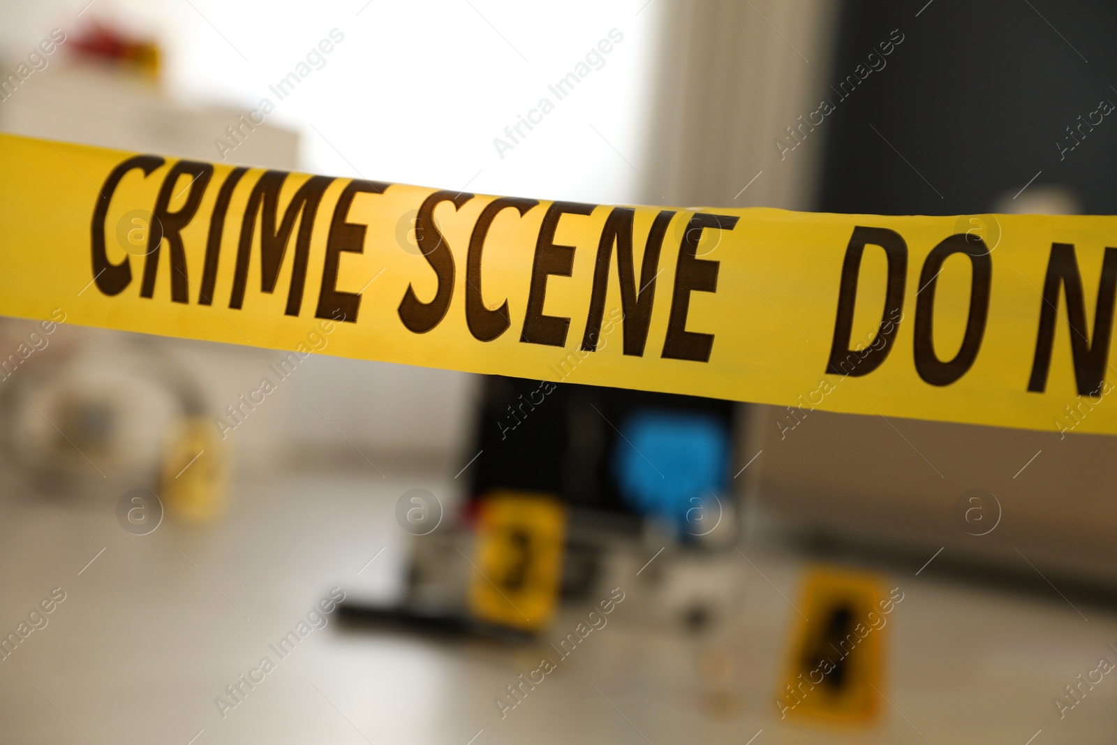 Photo of Crime scene with evidences and criminologist case, focus on yellow tape