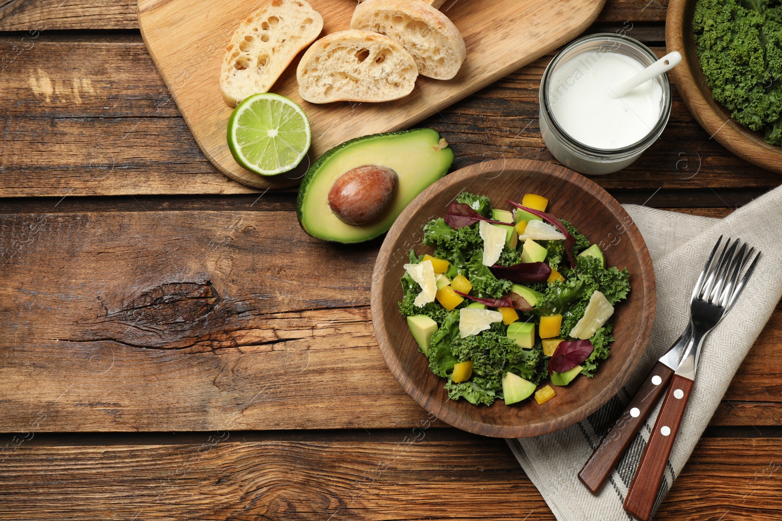 Photo of Delicious kale salad served on wooden table, flat lay