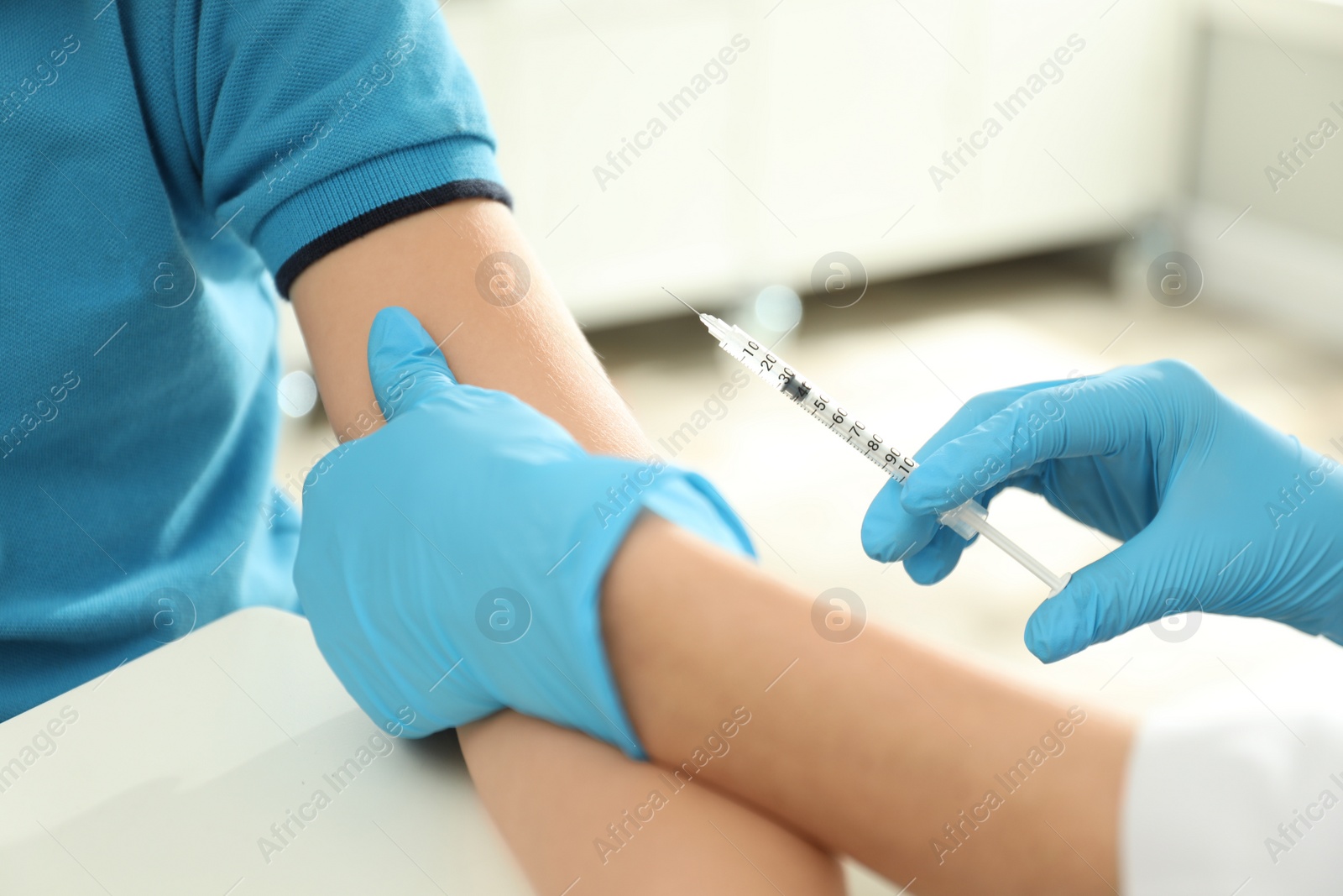 Photo of Doctor vaccinating little child in clinic, closeup