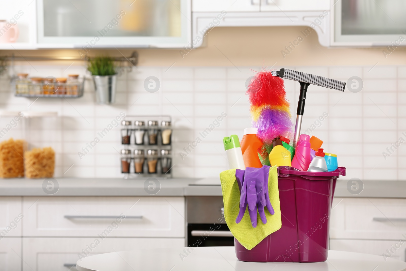 Photo of Set of cleaning supplies on table in kitchen. Space for text