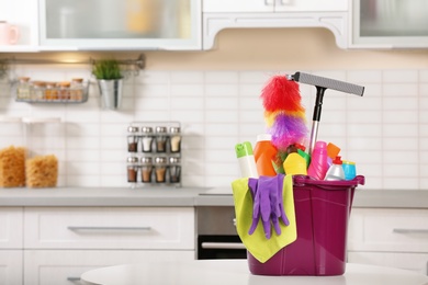 Set of cleaning supplies on table in kitchen. Space for text